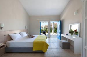 a bedroom with a bed with a yellow blanket at Ammoudia Maisonettes in Acharavi