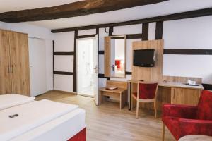 a hotel room with a bed and a desk and a tv at Hotel Stadt Kassel in Rinteln