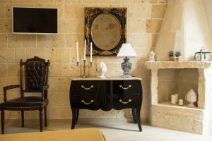 a bedroom with a black dresser and a chair and a mirror at HolidayMonopoli in Monopoli