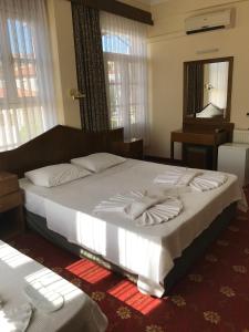 a bedroom with a large bed with towels on it at Antik Ridvan Hotel in Çeşme