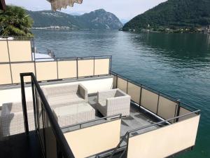 un bateau sur l'eau avec des chaises sur le pont dans l'établissement Casa Isabella, à Riva San Vitale