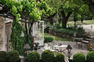 - un jardin avec une porte blanche, une table et des chaises dans l'établissement Le Mas Du Pont Roman, à Mane