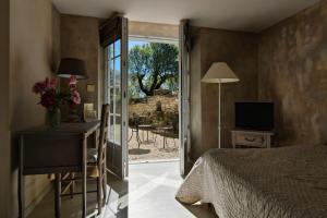 a bedroom with a bed and a sliding glass door at Le Mas Du Pont Roman in Mane