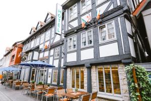 a row of tables and chairs in front of a building at Hotel Stadt Kassel in Rinteln