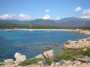 a view of a beach with boats in the water at Le Golfe in Figari