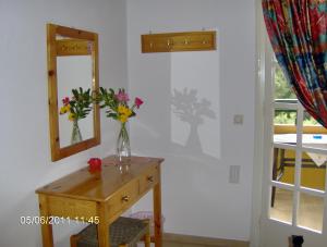a vase of flowers on a table with a mirror at Aphrodite Studios & Pool in Paleokastritsa