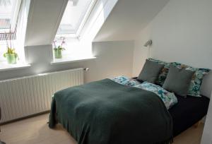 SælvigにあるSamsø Perlenのベッドルーム1室(ベッド1台付)、植物のある窓2つが備わります。
