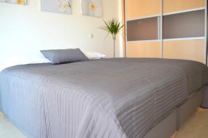 ラゴスにあるMarina Beach Apartmentのベッドルーム(白いシーツを使用した大型ベッド1台付)