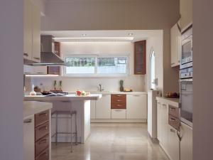 a kitchen with white cabinets and a kitchen island at Golden July Luxury Villa in Akrotiri