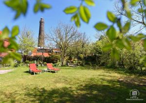 2 Stühle und ein Tisch auf einem Feld mit einer Fabrik in der Unterkunft Inselhotel VierJahreszeiten in Borkum