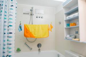 W łazience znajduje się prysznic i żółty ręcznik. w obiekcie Aparthotel Kachelot w mieście Borkum