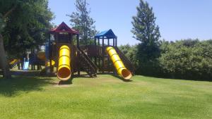 a playground with yellow slides in a park at Neot Golf Caesarea Garden Apartment in Caesarea