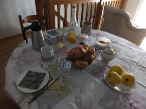 a table with a plate of food and fruit on it at Les 4 vents in Vineuil