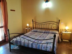 a bedroom with a bed and two tables with lamps at Sumindulau in Torre delle Stelle