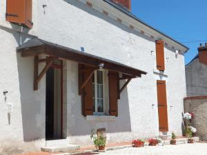 a white building with wooden shutters and a window at Les 4 vents in Vineuil
