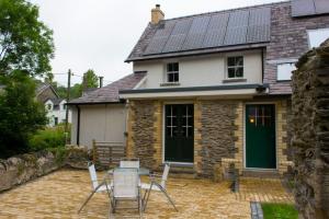 a patio with chairs and a table in front of a house at Old School B & B in Llandysul