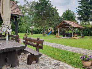a park with a wooden bench and a gazebo at Seoski turizam Sumak in Miljana