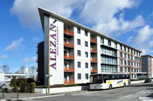 ein Bus, der vor einem großen Gebäude parkt in der Unterkunft Alezan Hôtel & Résidence in Toulouse