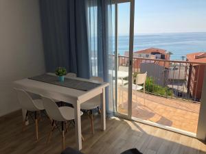 a dining room table with a view of a balcony at Apartamentos AR Muntanya Mar in Blanes