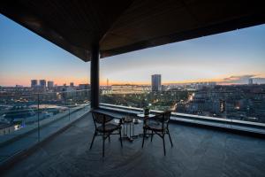 een tafel en stoelen op een balkon met uitzicht op de stad bij Wish More Hotel Istanbul in Istanbul