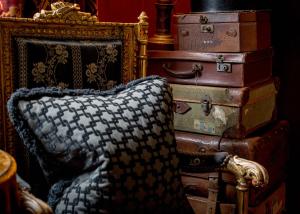 a chair sitting next to a stack of suitcases at Prestonfield House in Edinburgh