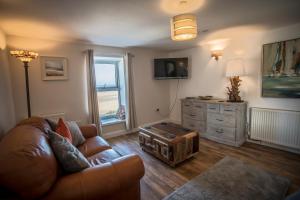 a living room with a couch and a table at Waters Edge Holiday Apartments in Benllech