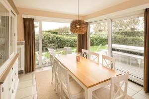 a dining room with a wooden table and chairs at Delmaro in Middelkerke