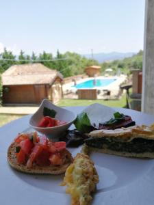 a white plate with a sandwich and a bowl of food at Agriturismo San Giorgio in Casal Velino