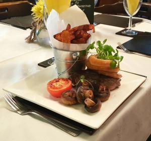 a plate of food with mushrooms and a basket of fries at The Pebley Inn in Chesterfield