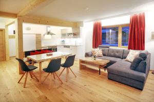 a living room with a couch and a table and chairs at Stockklauser in Lofer