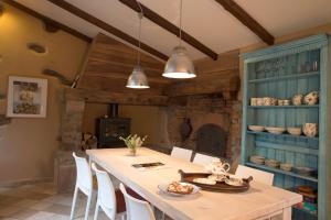 a dining room with a table with white chairs at La Maison de la Souque in Mirandol-Bourgnounac