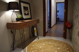 a hallway with a table with a lamp and a rug at Casa Lisboa Oriente in Lisbon