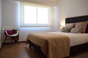 um quarto com uma cama com uma janela e uma cadeira em Casa Lisboa Oriente em Lisboa