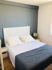 a bedroom with a large bed with a white headboard at Bel Appartement vue mer in Merville-Franceville-Plage