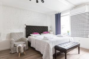 ジェロナ・グラにあるOne Night Zielona Góraの白いベッドルーム(大型ベッド1台、椅子付)