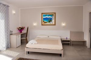 a bedroom with a bed and a table and a desk at Mariú Rooms in Castellammare del Golfo