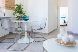 ein Wohnzimmer mit einem weißen Tisch und Stühlen in der Unterkunft Apartamentos Tendillas in Córdoba