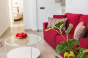 a living room with a red couch and a table at Apartamentos Tendillas in Córdoba