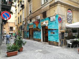 una strada cittadina con un edificio con un cartello stradale di Ciuciu' Naples Apartment a Napoli