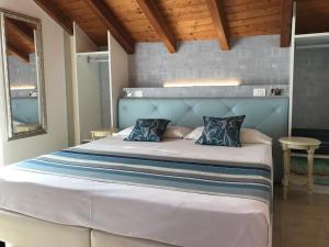 una camera con un grande letto con testiera blu di Hotel Souvenir a Monterosso al Mare