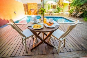 uma mesa com um prato de comida ao lado de uma piscina em Pousada Do Capitão em Florianópolis