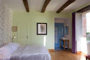ein Schlafzimmer mit einem Bett und einem Waschbecken darin in der Unterkunft La Maison de la Souque in Mirandol-Bourgnounac