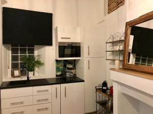 ナントにあるMagnifiques Appartements Hyper Centreのキッチン(白いキャビネット、黒いカウンタートップ付)