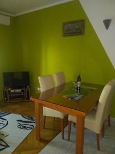 uma sala de jantar com uma mesa e uma parede verde em Apartment Ivan em Trogir