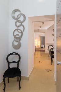 カターニアにあるetnart gallery houseの廊下(椅子2脚、壁彫刻付)