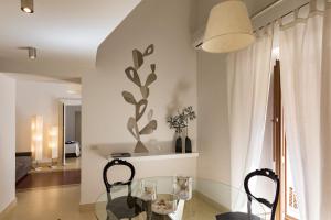a dining room with a glass table and chairs at etnart gallery house in Catania