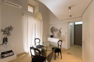 a dining room with a glass table and chairs at etnart gallery house in Catania