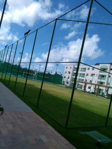 una rete con un campo da baseball dietro. di Apto Porto de Galinhas a Porto De Galinhas