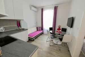 a kitchen and living room with a table and a couch at Apartment Cecilija in Sinj