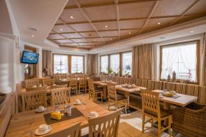 un restaurante con mesas y sillas de madera y ventanas en Chalet Walchenhof, en Mayrhofen